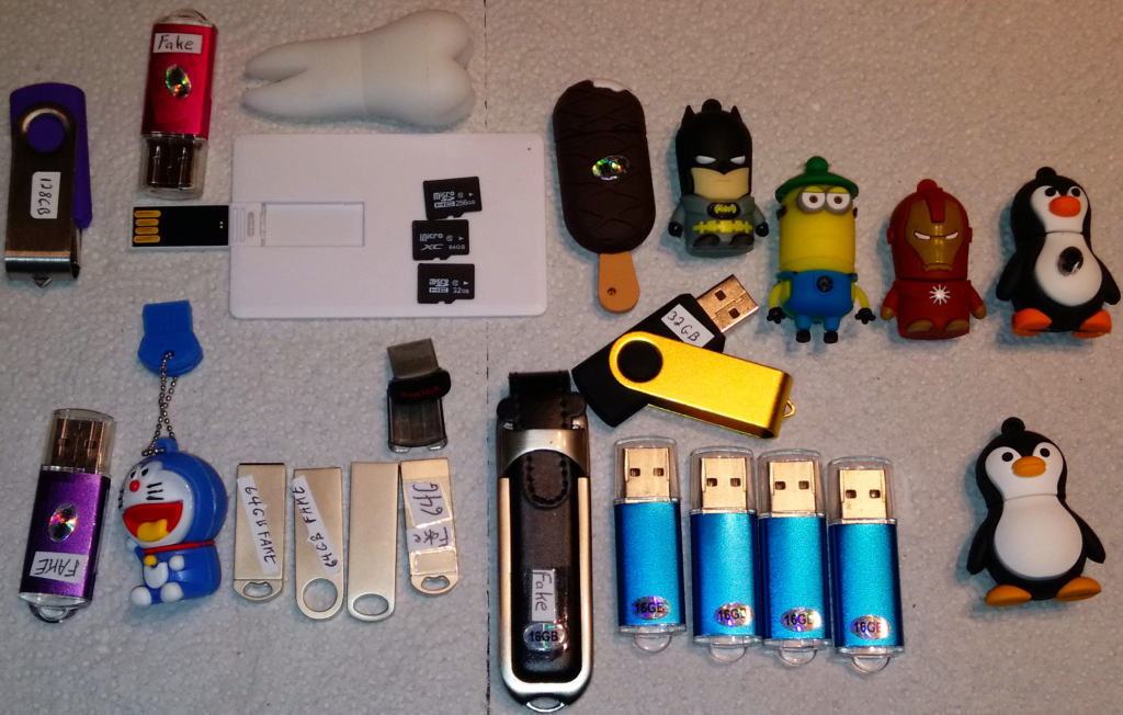 Two dozen fake USB and SD storage devices, all purchased on eBay, from sellers in Asia.